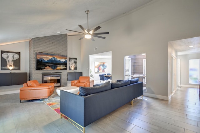 living room featuring a fireplace, high vaulted ceiling, and ceiling fan