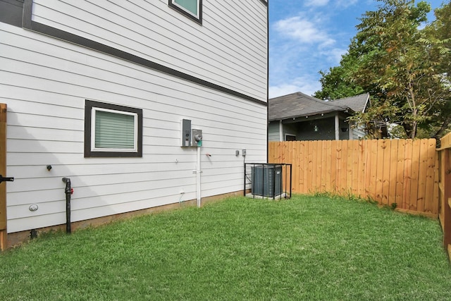 view of side of home with a lawn and cooling unit