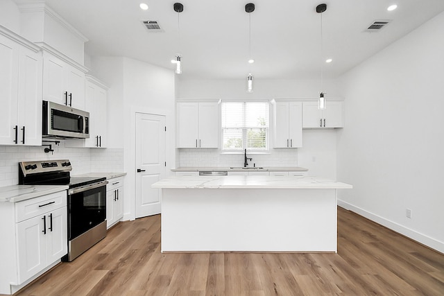 kitchen with white cabinets, stainless steel appliances, and a kitchen island