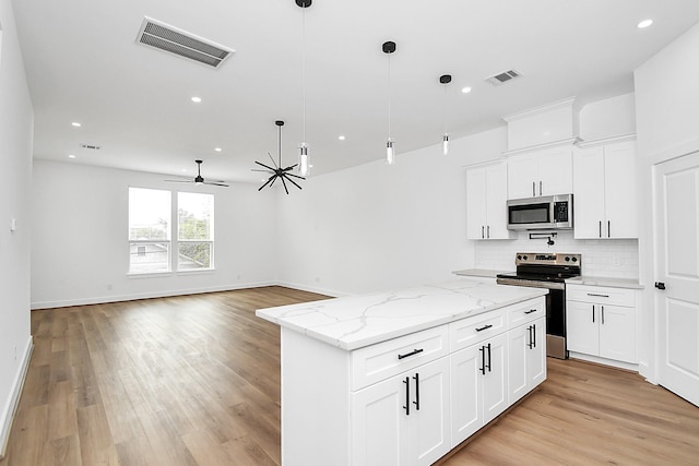 kitchen with white cabinetry, hanging light fixtures, and appliances with stainless steel finishes