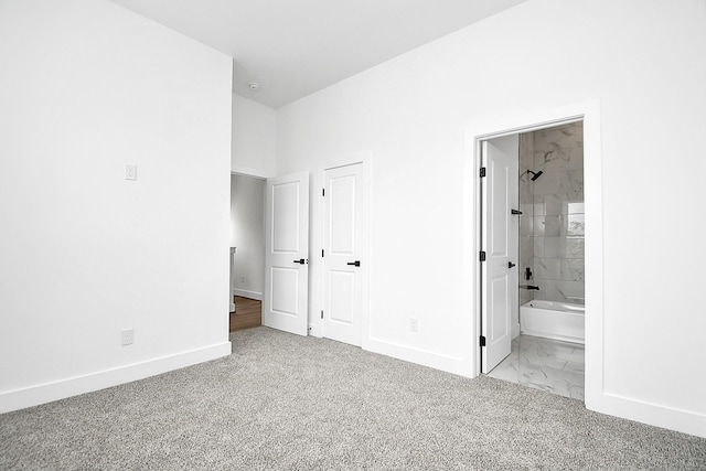 unfurnished bedroom featuring light carpet and connected bathroom