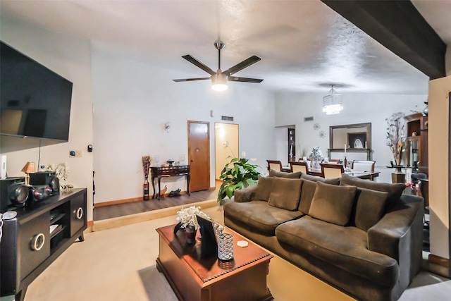 living room featuring ceiling fan with notable chandelier, light wood-type flooring, and high vaulted ceiling