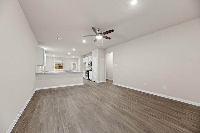 unfurnished living room featuring ceiling fan and hardwood / wood-style floors