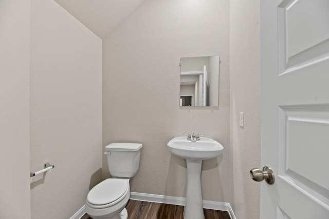 bathroom featuring hardwood / wood-style floors, vaulted ceiling, and toilet