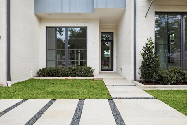 view of exterior entry with a lawn