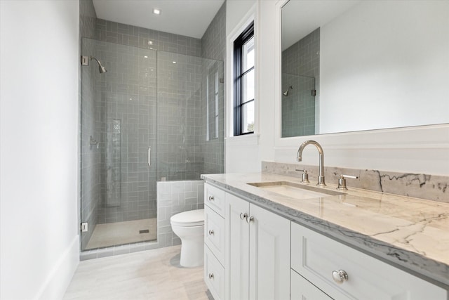 bathroom featuring tile patterned flooring, vanity, a shower with shower door, and toilet