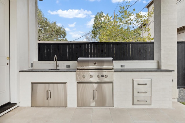 view of patio / terrace featuring an outdoor kitchen, area for grilling, and sink