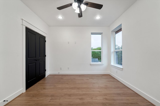 empty room with ceiling fan and light wood-type flooring