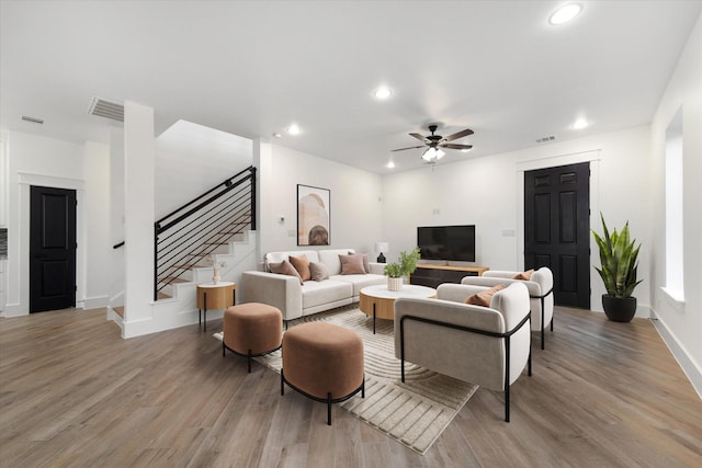 living room featuring light hardwood / wood-style floors and ceiling fan