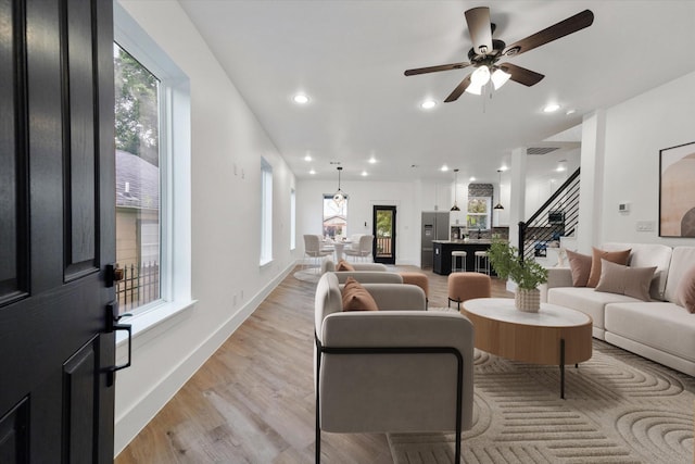 living room featuring ceiling fan and light wood-type flooring