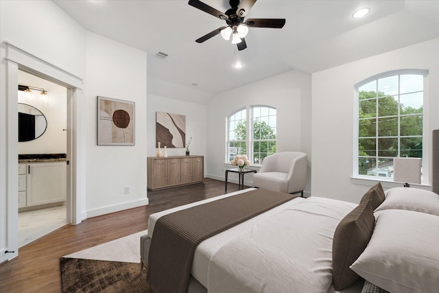 bedroom featuring hardwood / wood-style floors, ceiling fan, and ensuite bath