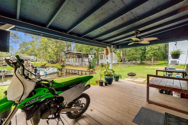 deck with a fire pit, ceiling fan, and a yard