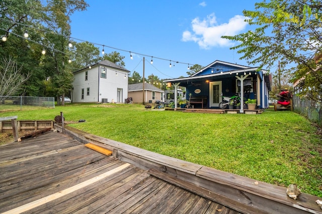 rear view of property featuring a wooden deck and a lawn