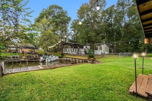 view of yard featuring a dock and a water view