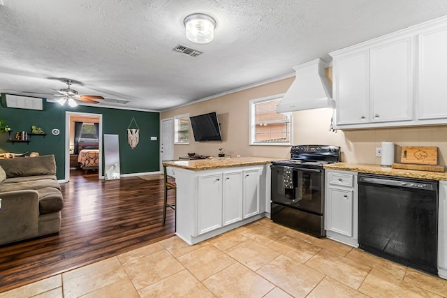 kitchen with custom exhaust hood, black appliances, white cabinets, light hardwood / wood-style flooring, and kitchen peninsula