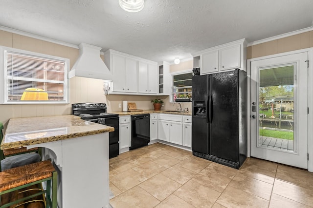 kitchen featuring white cabinetry, premium range hood, kitchen peninsula, crown molding, and black appliances