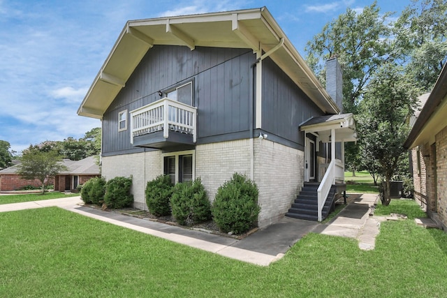 view of side of home featuring a yard and a balcony