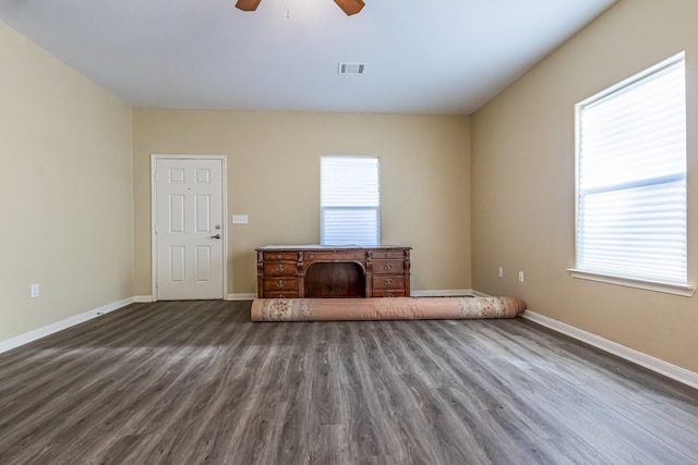 unfurnished living room with ceiling fan and dark wood-type flooring