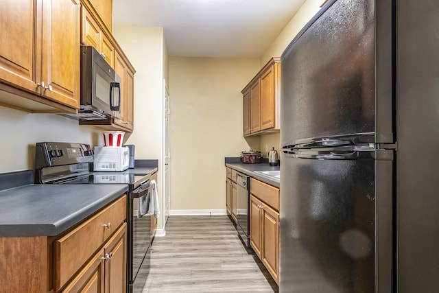 kitchen with light hardwood / wood-style floors and black appliances