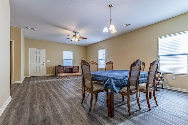 dining space featuring ceiling fan with notable chandelier and dark hardwood / wood-style floors