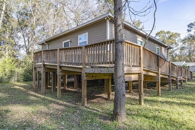 rear view of house featuring a yard and a wooden deck