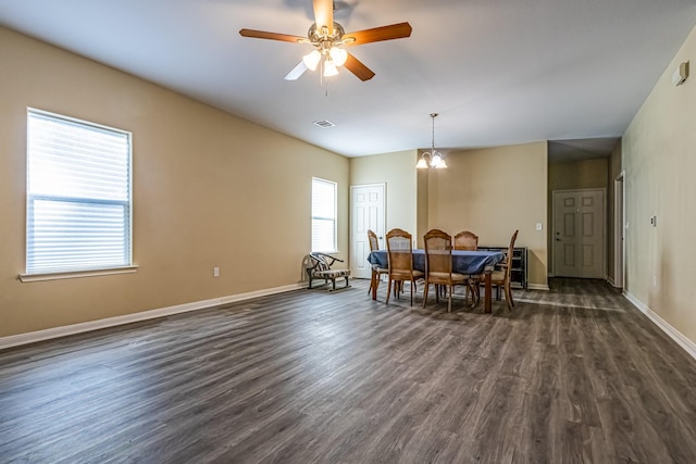 dining area featuring ceiling fan with notable chandelier and dark wood-type flooring