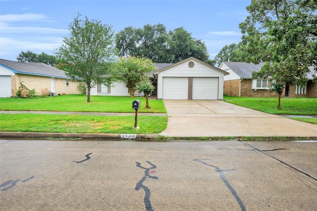 view of front of property featuring a garage, a front lawn, and concrete driveway