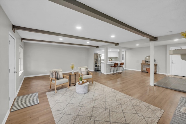 sitting room featuring beam ceiling and light hardwood / wood-style floors