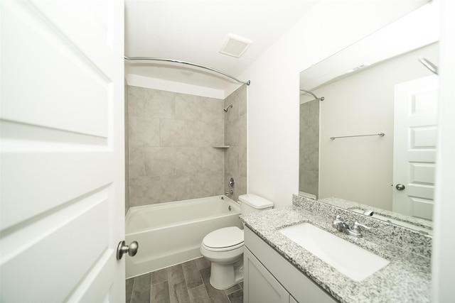 full bathroom with vanity, tiled shower / bath combo, hardwood / wood-style flooring, and toilet