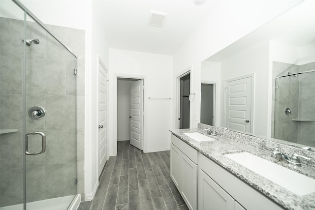 bathroom featuring vanity, wood-type flooring, and walk in shower