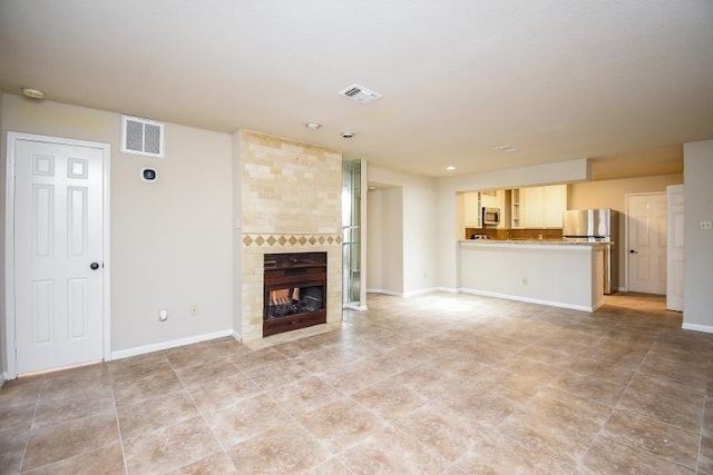 unfurnished living room featuring a fireplace and light tile patterned floors