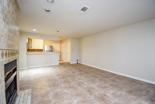 unfurnished living room with a fireplace and light tile patterned flooring