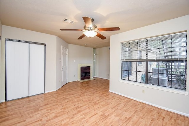 unfurnished living room with ceiling fan and light wood-type flooring