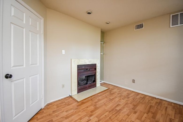 unfurnished living room with light hardwood / wood-style floors and a premium fireplace