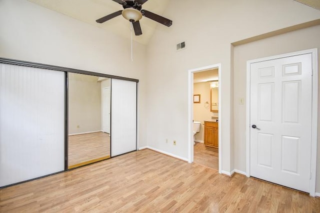 unfurnished bedroom with ceiling fan, ensuite bathroom, high vaulted ceiling, and light hardwood / wood-style floors