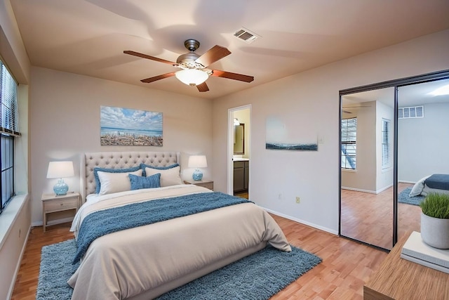 bedroom with a closet, hardwood / wood-style flooring, ceiling fan, and connected bathroom