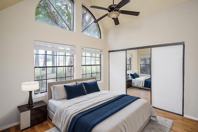 bedroom featuring light hardwood / wood-style flooring, multiple windows, and ceiling fan