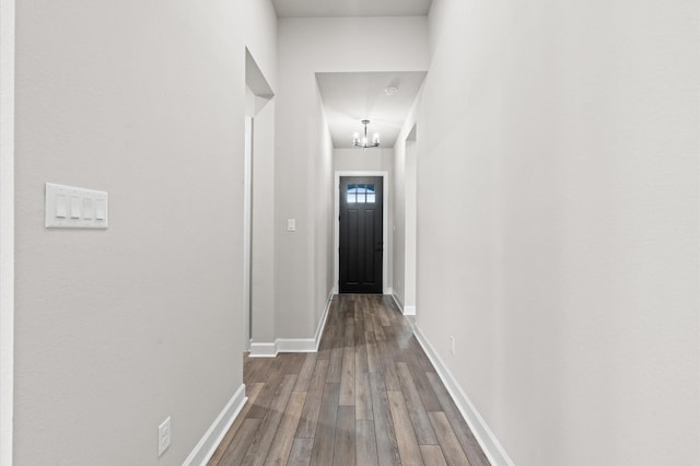 corridor featuring hardwood / wood-style floors and a chandelier