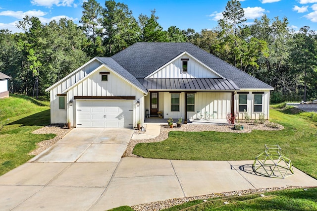 modern farmhouse with a shingled roof, a porch, a front yard, driveway, and a standing seam roof