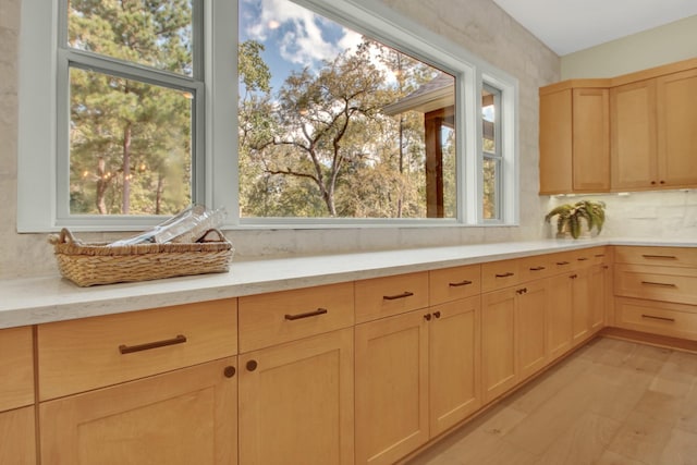 kitchen with plenty of natural light, light brown cabinets, and backsplash