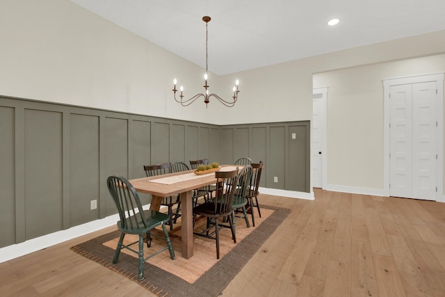 dining room with light hardwood / wood-style floors and a notable chandelier