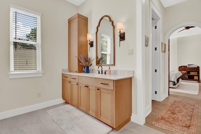 bathroom with a wealth of natural light, hardwood / wood-style floors, vanity, and ceiling fan