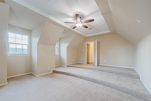 additional living space with ceiling fan, light colored carpet, and lofted ceiling