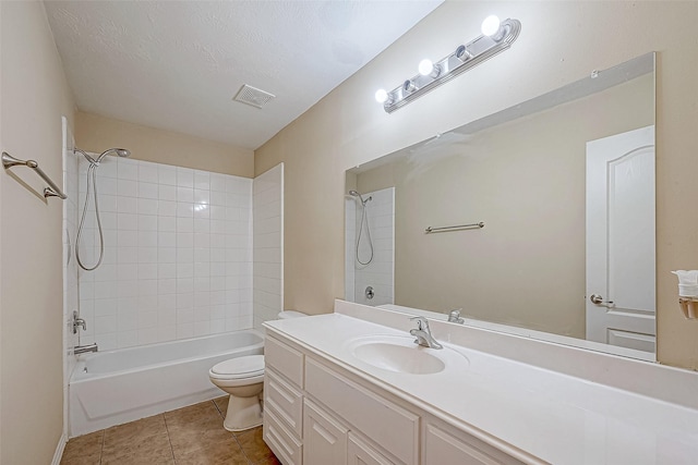 full bathroom featuring tile patterned floors, vanity, a textured ceiling, toilet, and tiled shower / bath