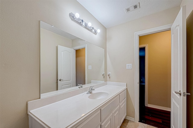 bathroom featuring tile patterned flooring, a textured ceiling, and vanity