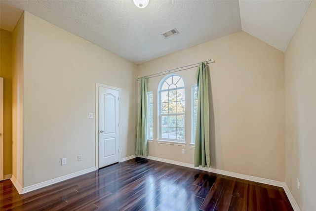 unfurnished room featuring a textured ceiling, dark wood-type flooring, and lofted ceiling