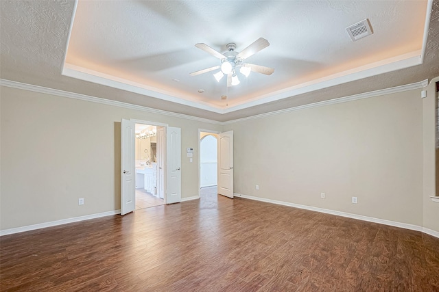 spare room with hardwood / wood-style flooring, a raised ceiling, ornamental molding, and a textured ceiling