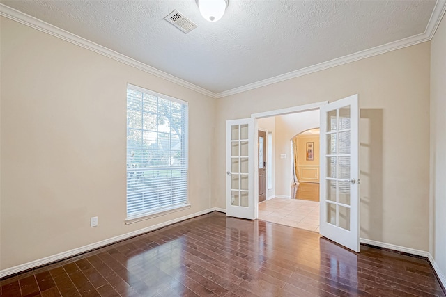 spare room with french doors, a textured ceiling, crown molding, and wood-type flooring