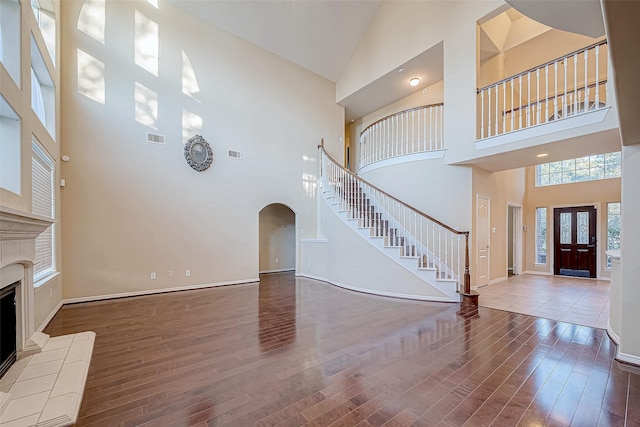 unfurnished living room featuring a fireplace, hardwood / wood-style flooring, and high vaulted ceiling