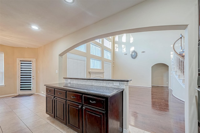 kitchen featuring dark brown cabinetry, a kitchen island, and light wood-type flooring